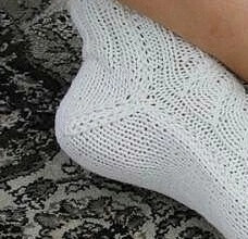 Красивые белые носки на двух спицах с имитацией кос по центру . Красивые белые носки на двух спицах с имитацией кос по центру .
